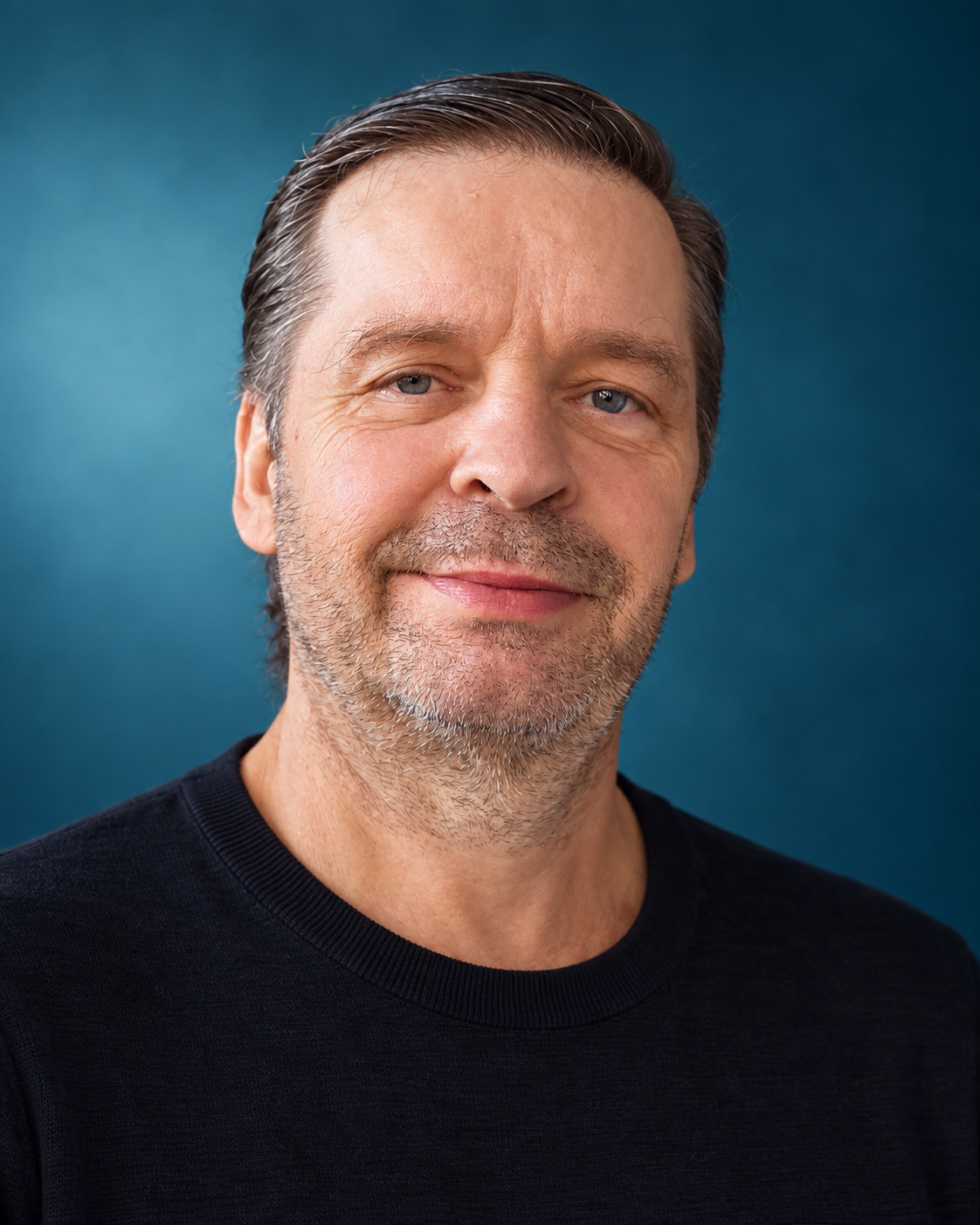 Porträt von Marek Olbrys vor blauem Hintergrund